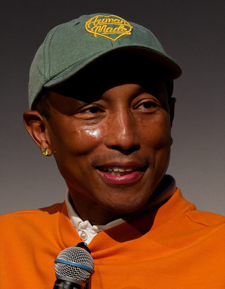 Pharrell Williams: Green cap and orange sweatshirt